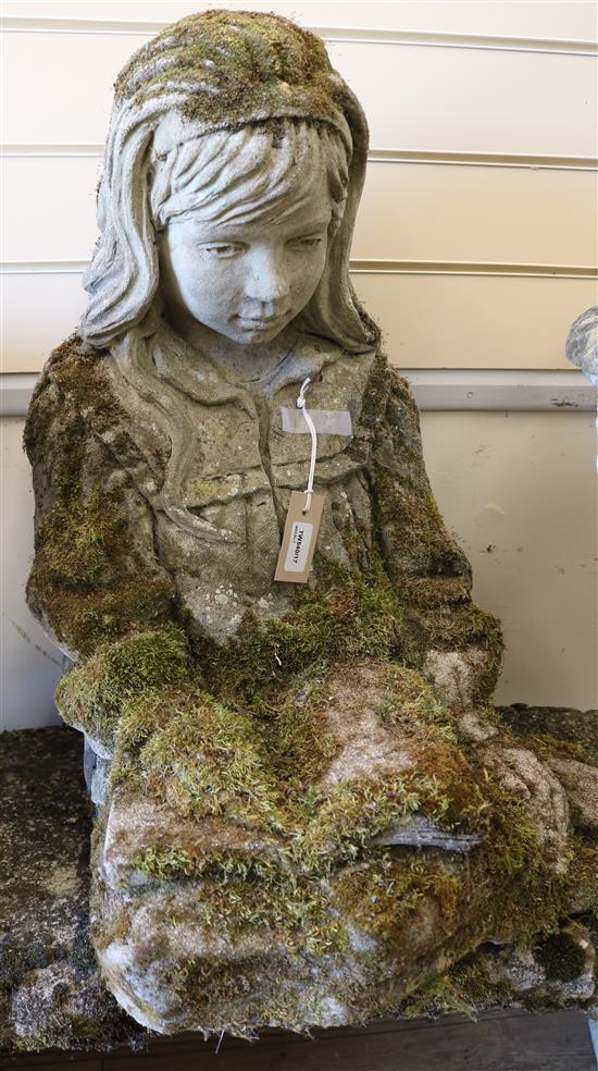 A reconstituted stone garden stature modelled as a seated young girl reading a book W.50cm approx